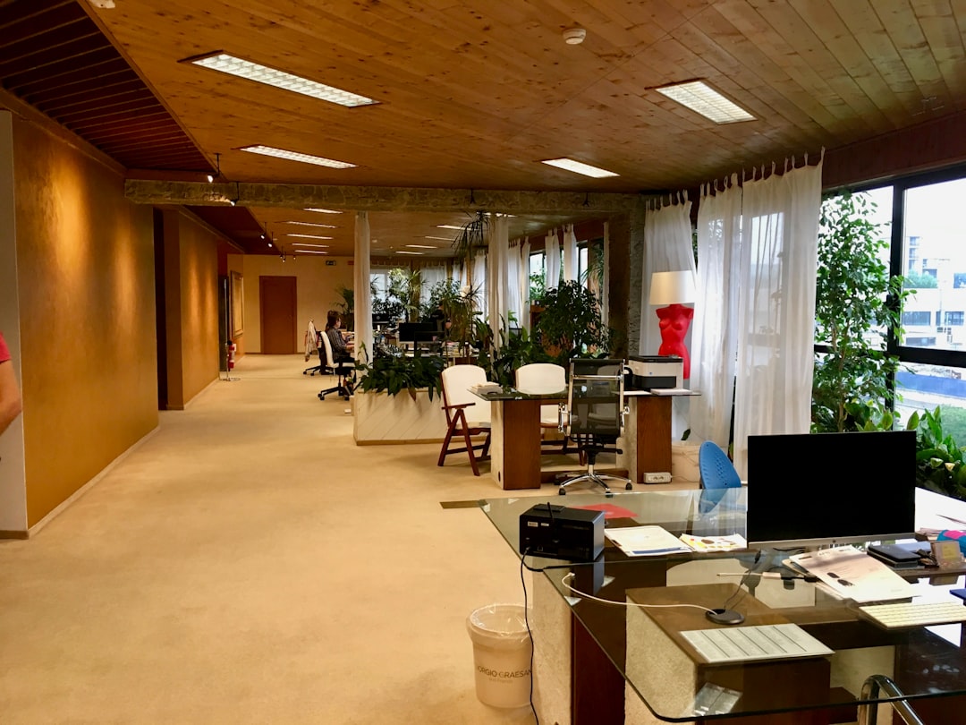 black-monitor-on-table-near-printer-paper-on-office-area-of-the-building-with-no-people-ypdnohh8yto